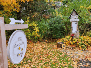 Fall honey stand surrounded by colorful autumn leaves.